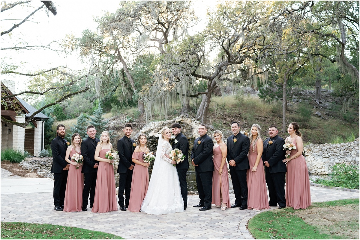 bride-and-groom-with-bridal-party-in-mauve-dresses-and-black-tuxedos 
