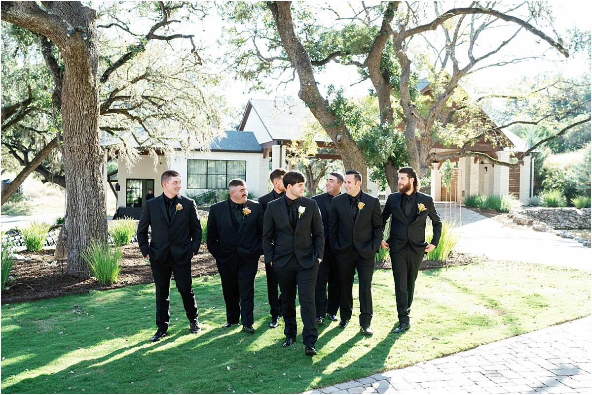 groom-walking-with-groomsmen-in-black-tuxedos