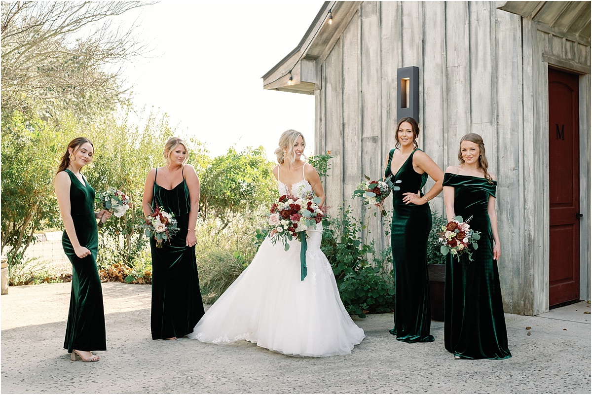 bride-posed-with-bridesmaids-in-emerald-green-dresses 