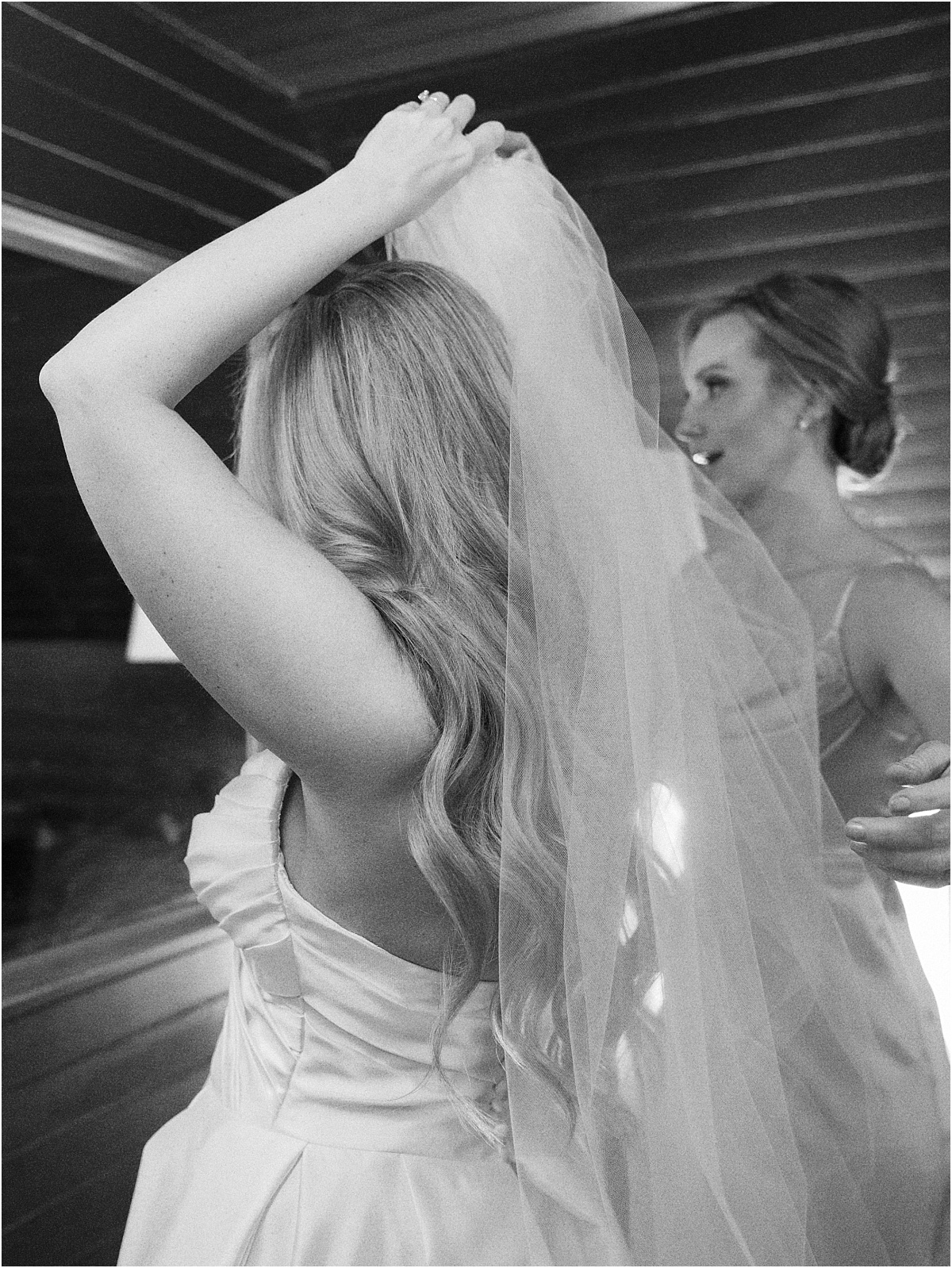 Bride putting on wedding veil.