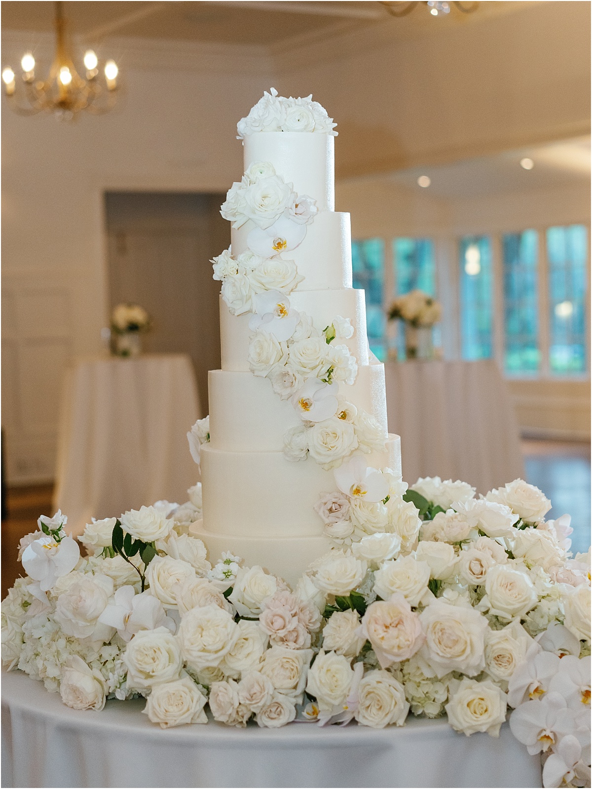 5 tier white wedding cake with cascading roses.