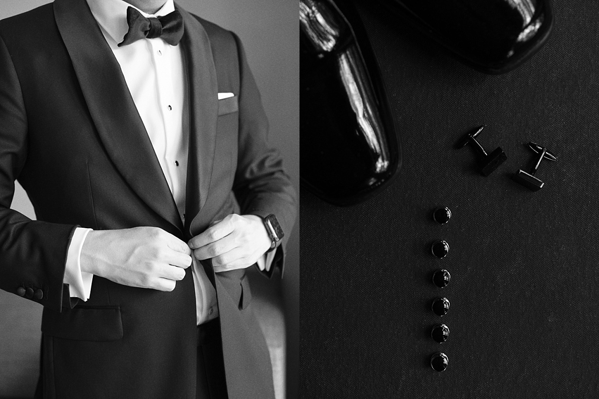 Groom buttoning his suit jacket.