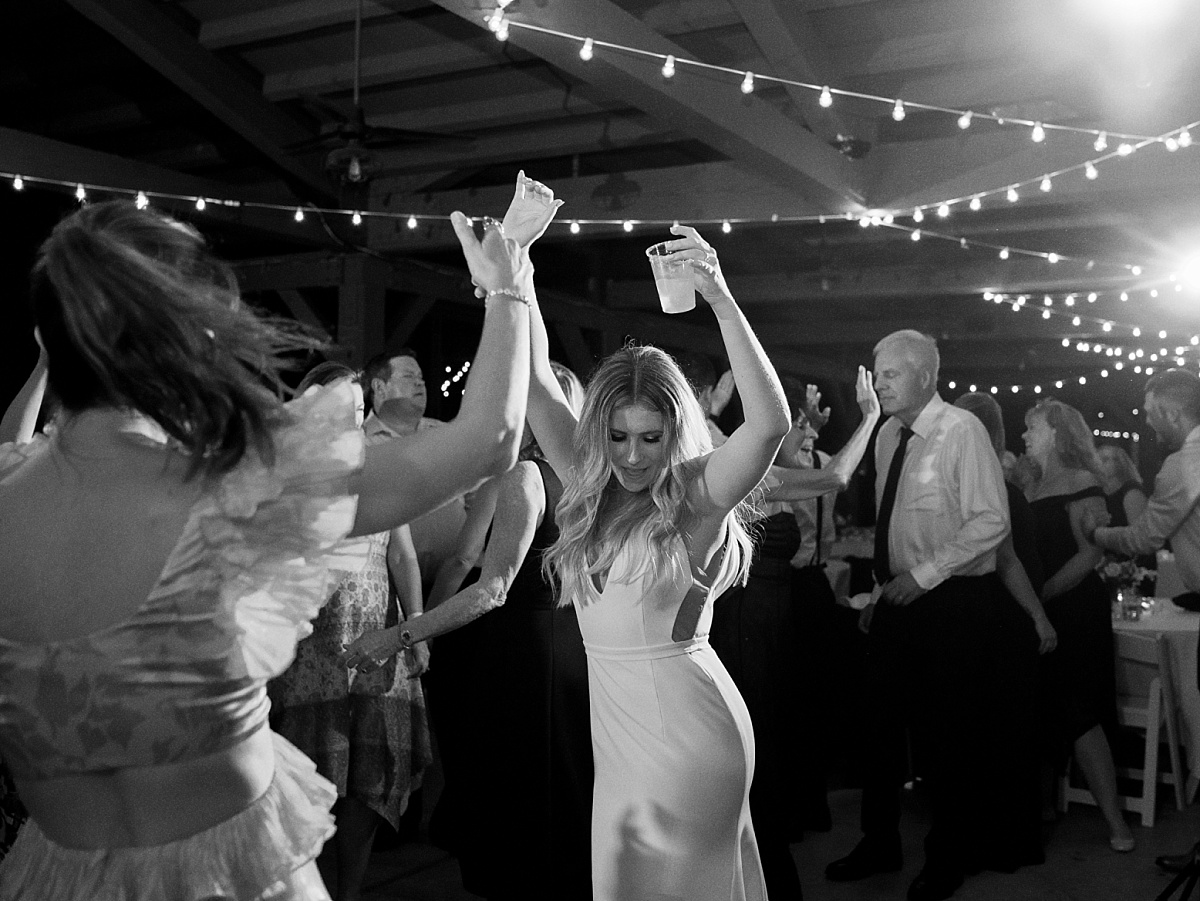 Bride dancing with her hands in the air during the wedding reception.