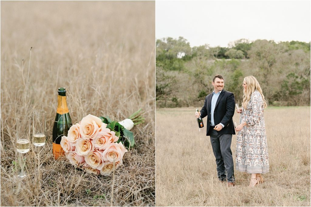 Couple popping champagne in an open field.