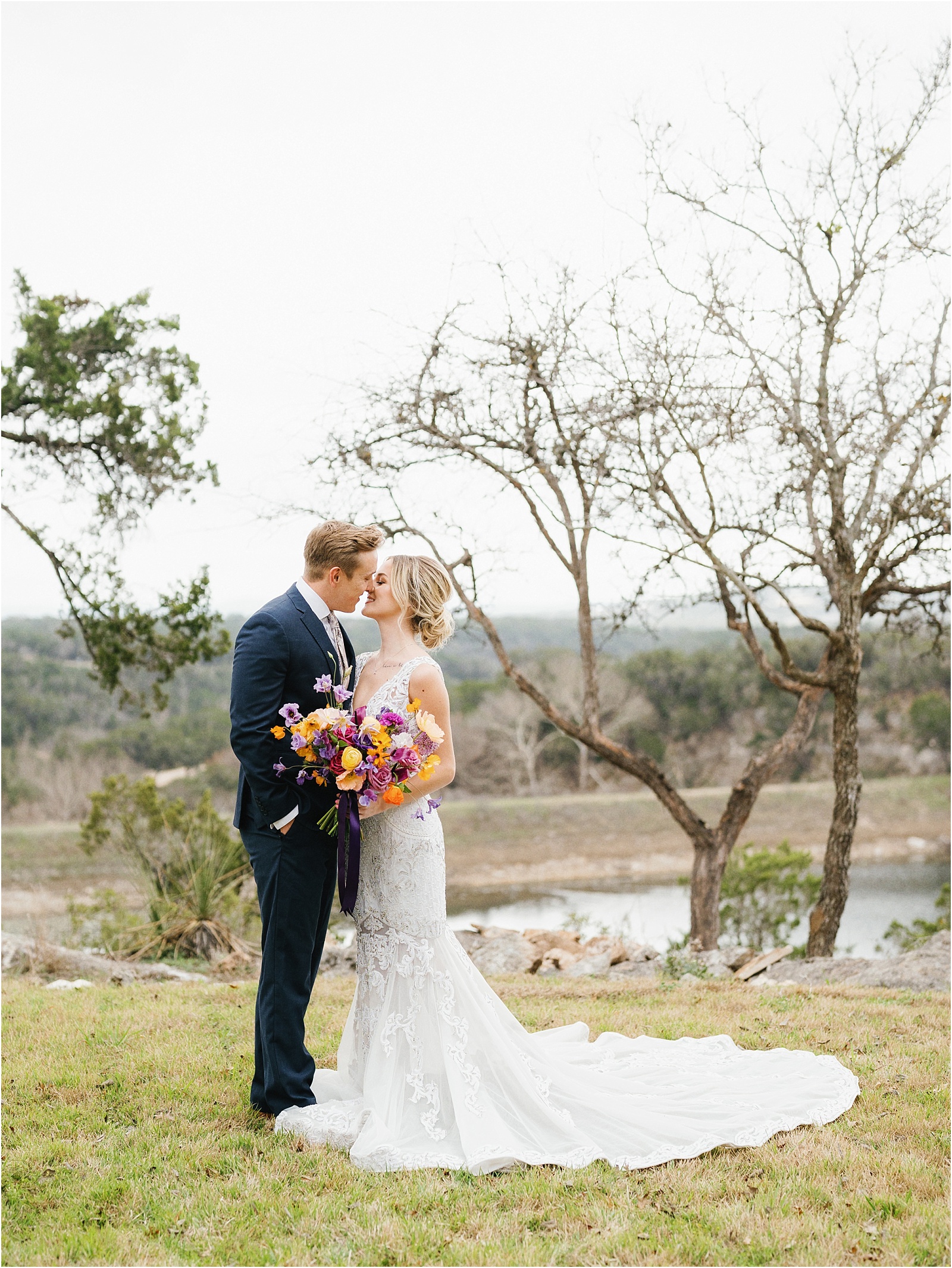 Bride and groom embracing over looking the lake at The Videre Estate.