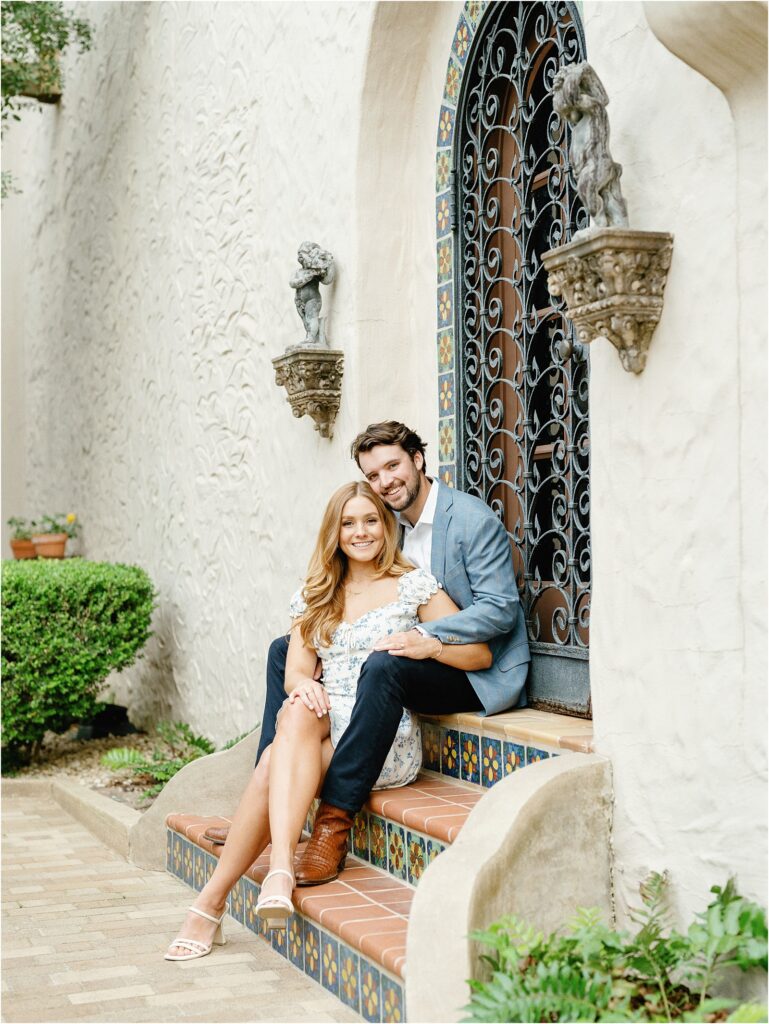 couple sitting on the tiled steps in the courtyard of the McNay Museum.