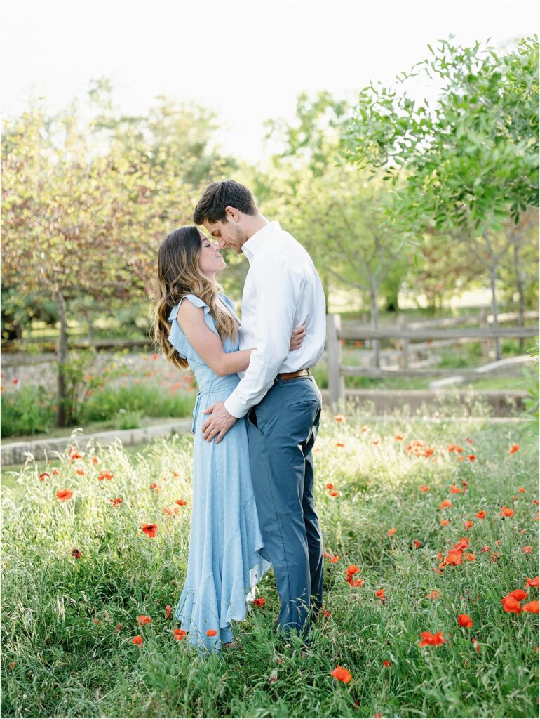 Couple hugging during their spring engagement session in a park in Austin. 