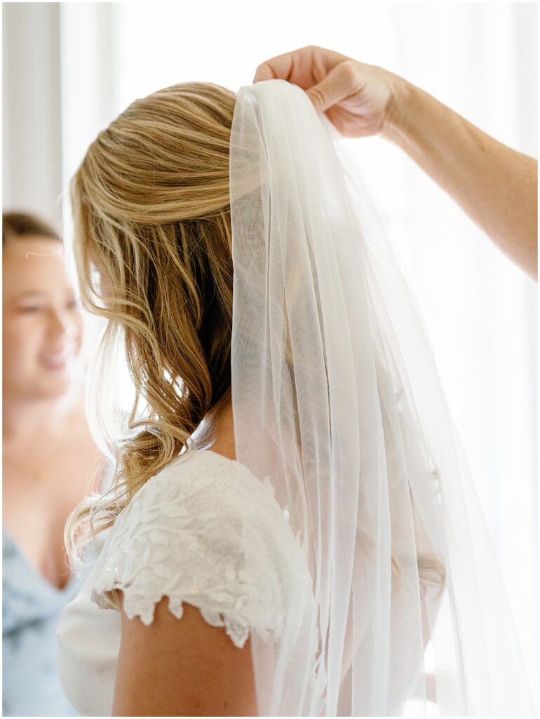 Bride putting on her veil in the bridal suite at The Grand Lady.