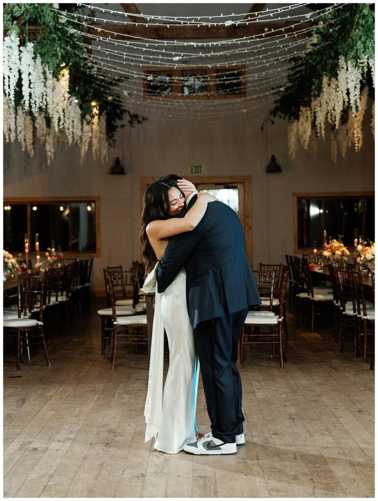 Savana and Casey share an intimate private last dance in the softly lit reception area, savoring a quiet moment together before the night ends.