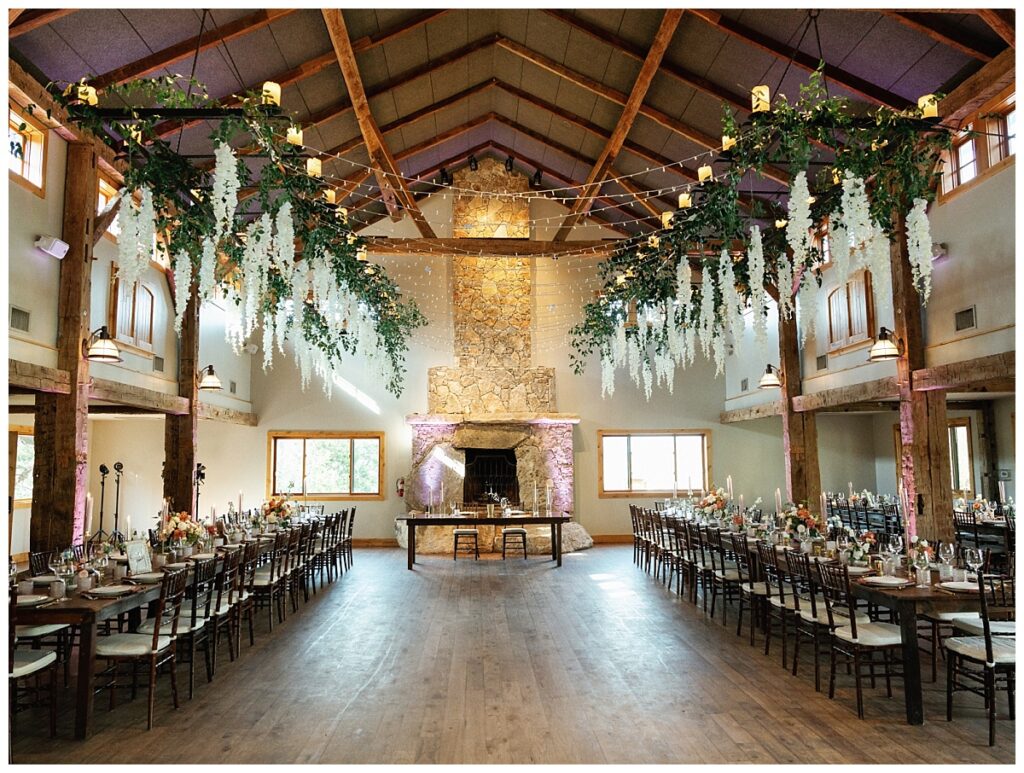 The reception hall at Camp Lucy, adorned with lush floral arrangements hanging from the ceiling, creating a dreamy ambiance.