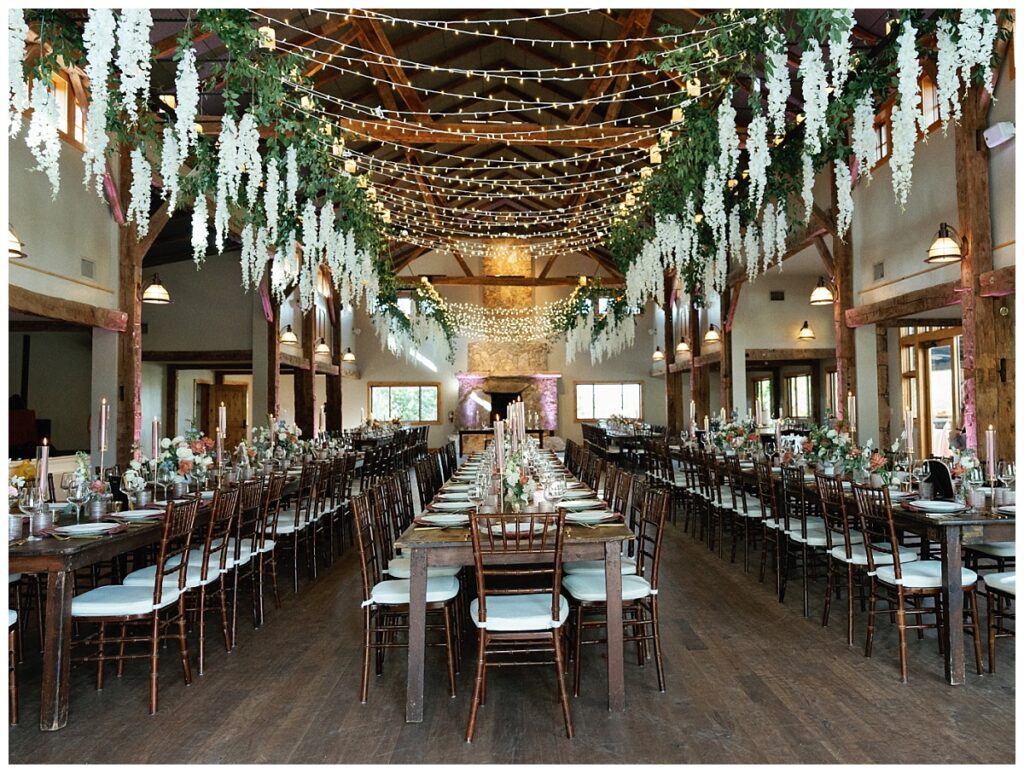 The reception hall at Camp Lucy, adorned with lush floral arrangements hanging from the ceiling, creating a dreamy ambiance.