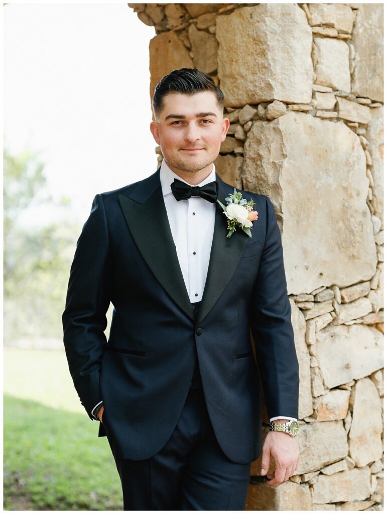 The groom stands under the ancient oak trees near Ian's Chapel, looking dapper and ready for the ceremony.