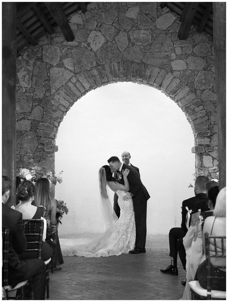 The bride and groom share their first kiss as husband and wife at the altar inside Ian's Chapel.