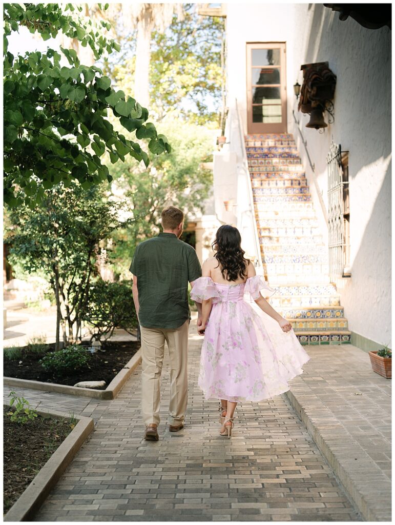 Candid moment of Catherine and Reuben walking hand-in-hand through the gardens of The McNay Art Museum in San Antonio