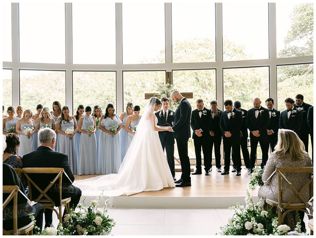 Indoor wedding ceremony at The Preserve at Canyon Lake with floor-to-ceiling windows overlooking the water.