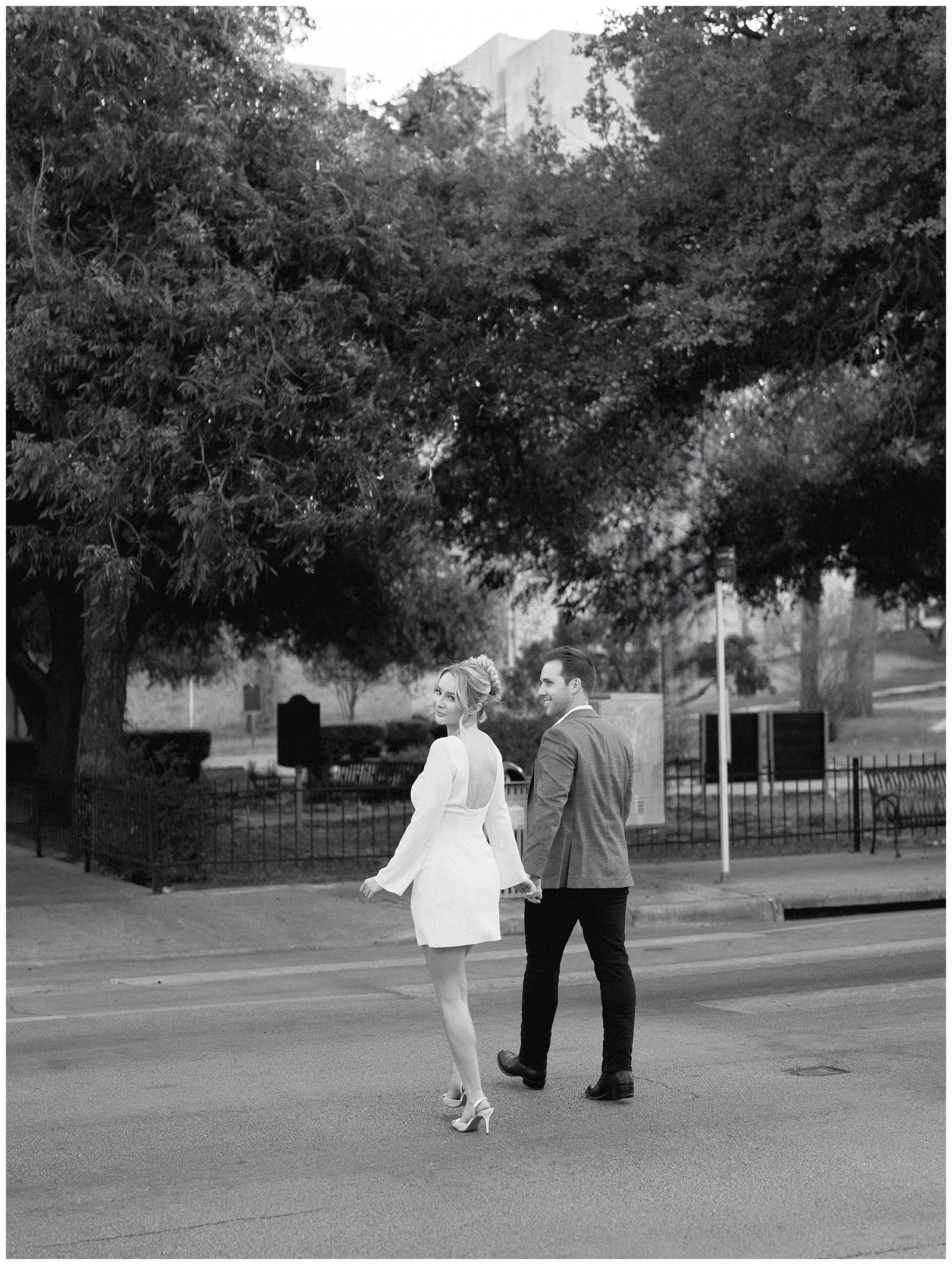 Modern couple walking hand in hand during downtown Austin engagement session on Congress Avenue